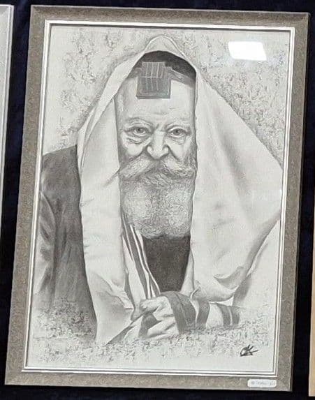 Le portrait du Rabbi sous le talith dans un cadre gris, posé sur un velours bleu nuit