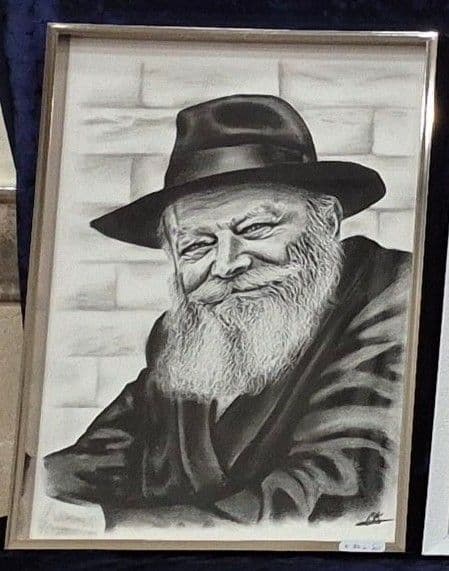 Le portrait du Rabbi souriant dans un cadre argenté, posé sur un velours bleu nuit